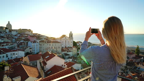 Ein-Mädchen-Fotografiert-Den-Sonnenaufgang-über-Alfama-In-Lissabon,-Portugal