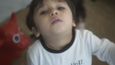 Candid-shot-of-toddler-little-boy-waving-a-pencil-at-camera