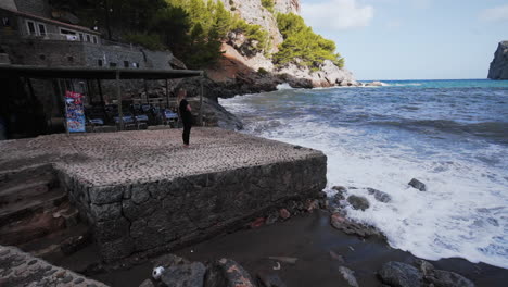 Girl-watches-the-Waves-in-the-Port-of-Sa-Calobra,-Mallorca