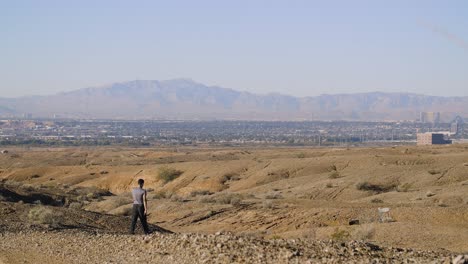 Ein-Junger-Mann-Bahnt-Sich-Seinen-Weg-Durch-Die-Hügelige-Wüstenlandschaft-Richtung-Las-Vegas-Valley