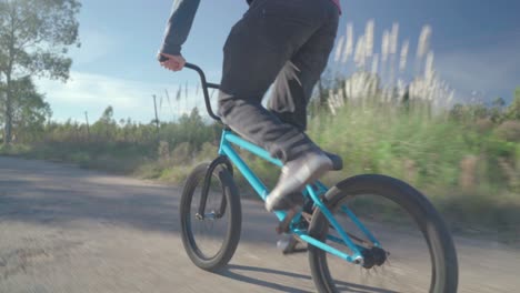 Young-man-rides-on-bmx-down-an-abandoned-road