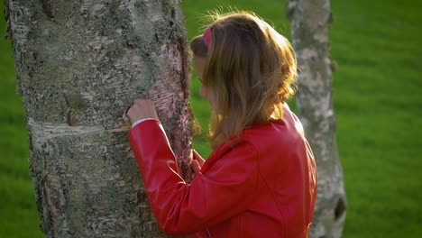 Attractive-teenage-girl-peeling-off-silver-birch-tree-bark