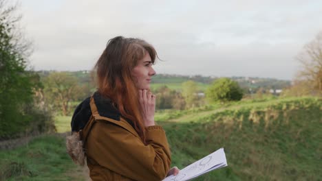 Young-woman-on-a-field-with-notes-in-hand-looking-for-the-right-way-on-a-nature-trail