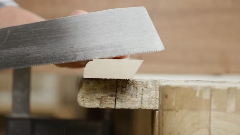 Side-view-close-up-of-hand-saw-cutting-off-end-piece-to-shorten-batten