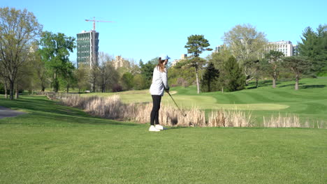 HD-Aufnahmen-Einer-Frau,-Die-An-Einem-Sommertag-Auf-Einem-Schönen-Golfplatz-Golf-Spielt