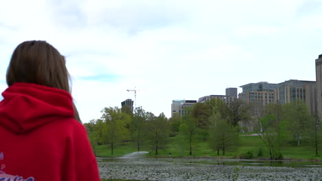 Nice-shot-of-girl-overlooking-a-lake-and-city-at-Forest-Park-in-St