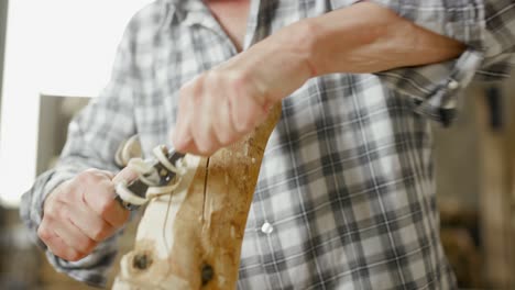 Carpenter-uses-two-handed-plane-to-plane-wooden-workpiece