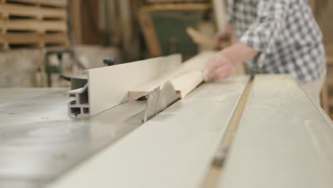 Long-wooden-board-is-pushed-precisely-along-circular-saw-to-cut-off-thin-latch