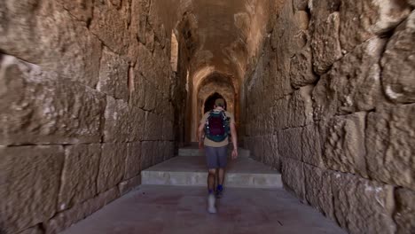 Adventurer-walking-through-ancient-coliseum,-Jerash,-Jordan,-wide-angle,-traveling-shot