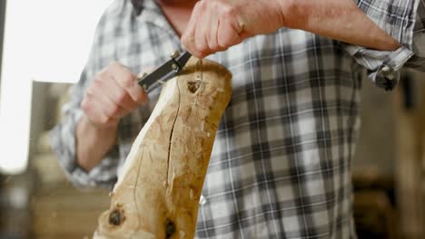 Wood-worker-planes-raw-workpiece-and-brings-it-into-form