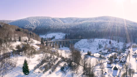 Winter-mountain-countryside-with-a-railway-viaduct-above-a-village