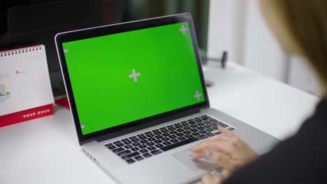 A-woman-was-tapping-her-hand-on-the-laptop-keyboard，Laptop-green-screen