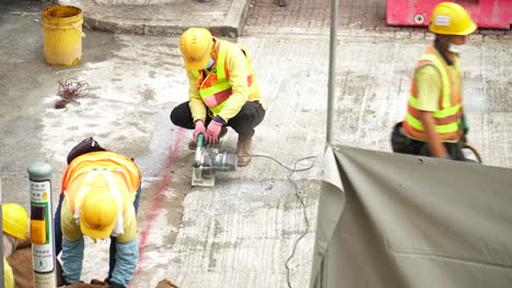 Aerial-close-up-of-a-construction-worker-performing-stone-cutting-work-in-concrete