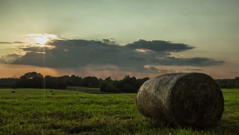 Cloud-movement-in-timelapse-over-straw-bales-on-green-grasslands