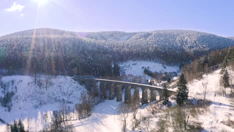 Personenzug-überquert-Bei-Schneefall-Einen-Steinernen-Eisenbahnviadukt,-Zoom