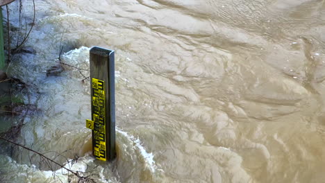 At-a-water-level-meter-standing-in-the-river,-you-can-read-the-water-level-at-high-water