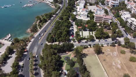 Ein-Drohnenvideo,-Das-Sich-Von-Einer-Autobahn-Nach-Oben-Neigt,-Um-Eine-Kleine-Griechische-Stadt-Zu-Enthüllen