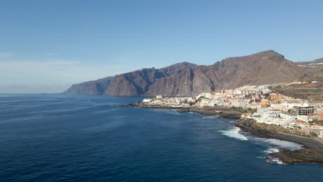 Aerial-view-of-the-Los-Gigantes-cliffs-and-Puerto-Santiago-on-the-island-of-Tenerife,-Canary-Islands,-Spain