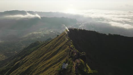 Tourist-people-standing-on-crater-ridge-of-Mount-Batur-in-Bali,-sunrise