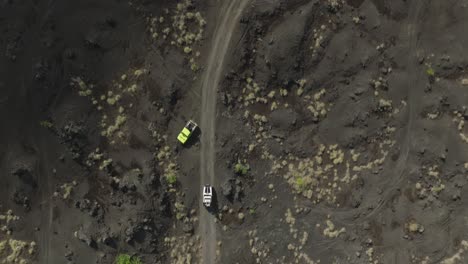 Vehículo-Jeep-4x4-Conduciendo-A-Través-De-Un-Paisaje-De-Arena-Volcánica-Seca,-Aéreo