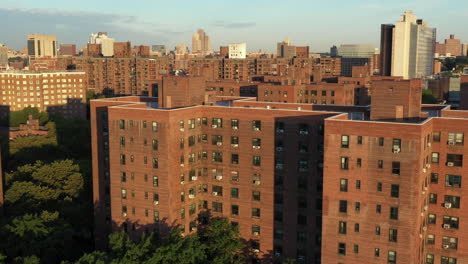 Cinematic-pivot-pan-aerial-shot-of-public-housing-project-buildings-in-Harlem-New-York-City-at-sunrise