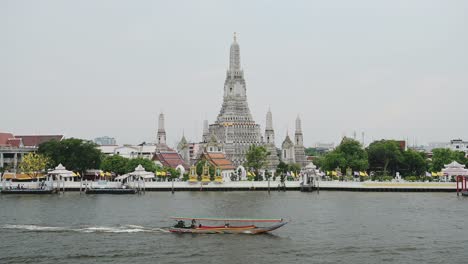 Thailand-Bangkok-River-City-Scene,-Tourist-Boat-Trip-Water-Taxi-and-Buddhist-Temple-of-Wat-Arun-Cityscape-Skyline,-Famous-Beautiful-Building-and-Popular-Tourist-Landmark,-Asia