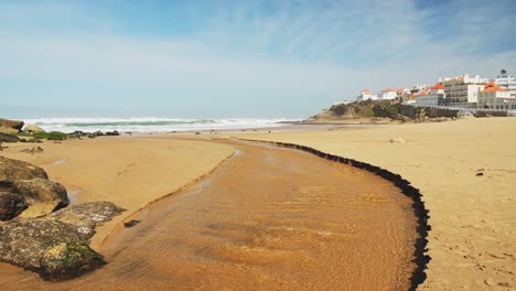 Luftdrohnenansicht-Des-Sandstrandes-In-Lissabon,-Portugal-Am-Praia-Das-Macas,-Einer-Wunderschönen-Küstenstadt-An-Der-Atlantikküste-Auf-Einer-Klippe,-Einem-Beliebten-Touristenziel-In-Europa-1