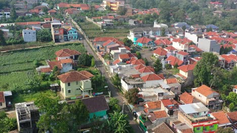 Local-Indonesian-homes-surrounded-by-gardens-in-Bandung-Indonesia-at-sunrise,-aerial