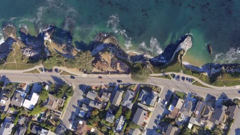A-luxury-community-in-Santa-Cruz,-California-with-homes-along-West-Cliff-Drive-and-one-mansion-on-the-cliffs-overlooking-the-ocean---straight-down-aerial-view