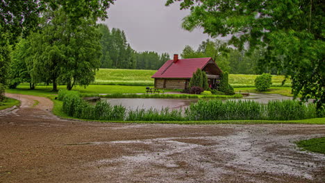 Picturesque-Landscape-Of-Farm-House-On-The-Bank-Of-River-With-Green-Surroundings