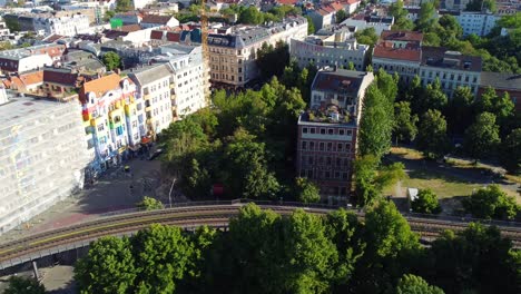 Overview-of-the-district-Kreuzberg-from-Friedrichshain-elevated-railroad-Beautiful-aerial-view-flight-tilt-up-drone-footage-of-Berlin-sunny-Summer-day-2022-Cinematic-view-from-above-by-Philipp-Marnitz