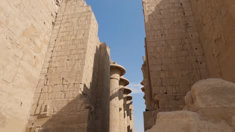 Looking-Up-At-Sandstone-Walls-With-Carvings-At-Karnak-Temple-Complex-In-Egypt