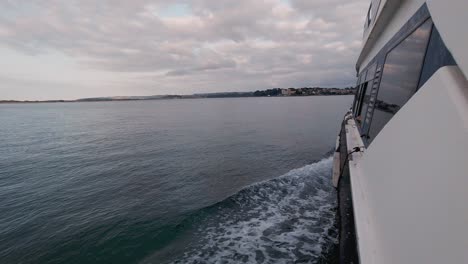 Revealing-shot-from-boat-in-Santander-bay-view-from-a-ferry-boat-during-sunset-cloudy-summer-day