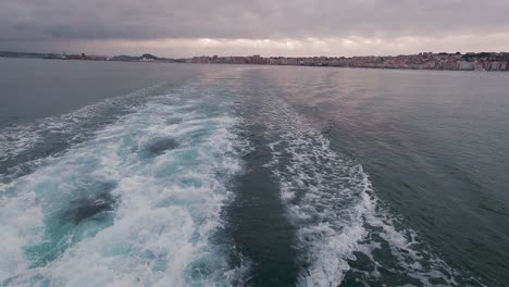 Tilt-up-view-of-Santander-bay-view-from-a-ferry-boat-during-sunset-cloudy-summer-day