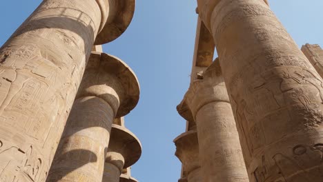 Mirando-Hacia-Los-Pilares-De-Arenisca-En-El-Complejo-Del-Templo-De-Karnak-En-Egipto-Con-Movimiento-Inclinado-Hacia-Abajo