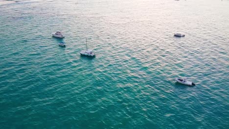 Aerial-drone-shot-of-the-ocean-in-the-Dominican-republic-passing-boats-that-are-floating