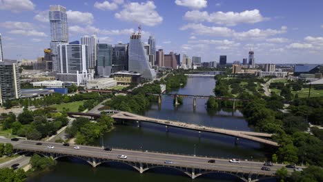 Aerial-view-over-bridges-on-the-Colorado-river-in-Austin-city,-sunny,-summer-day-in-Texas,-USA