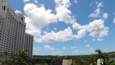 Timelapse-of-luxury-hotel-in-Nassau-Bahamas-Baha-Mar-resort-with-white-clouds-and-blue-sky-and-palm-trees-in-the-distance-B-roll