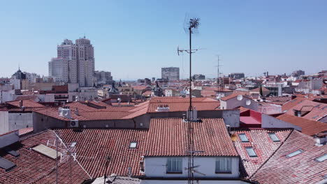 Eine-Sockeldrohne,-Die-Sich-über-Einem-Traditionellen-Spanischen-Dach-Mit-Tonnenfliesen-Erhebt,-Um-Das-Größere-Stadtbild-Des-Malasaña-viertels-In-Madrid,-Spanien,-Zu-Enthüllen