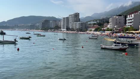 Hafen-Und-Strand-In-Einer-Kleinen-Stadt-In-Montenegro-Namens-Rafilovicci-An-Einem-Sehr-Heißen-Und-Schönen-Tag-Voller-Touristen-Und-Einheimischer,-Die-Eine-Gute-Zeit-Haben-Und-In-Der-Sonne-Entspannen-Und-Sich-Sonnen