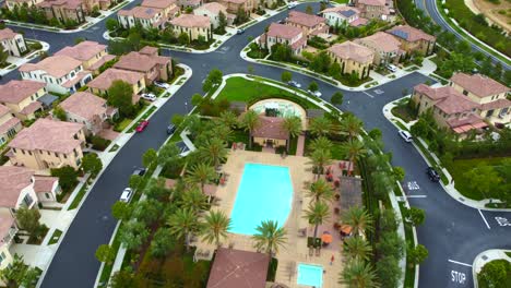 Wohlhabende-Nachbarschaft-In-Irvine-City,-Orange-County-Ca-Usa,-Luftaufnahme-Des-Gemeinschaftspools,-Der-Straßen-Und-Häuser,-Drohnenaufnahme