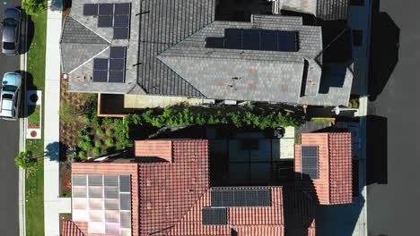 Solar-panels-on-residential-homes---descending-aerial-vertical-orientation
