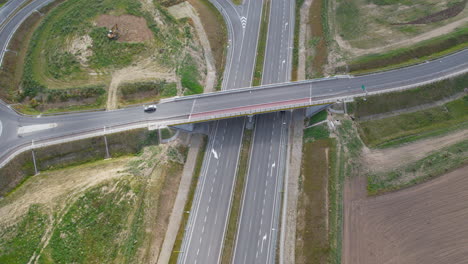 Aerial-View-Of-Cars-Driving-On-Elevated-Road-Over-Empty-Highway