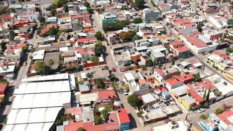 Drone-footage-of-residential-area-in-Oaxaca-City,-Mexico-on-a-sunny-day-with-vibrant-traditional-Mexican-rooftops