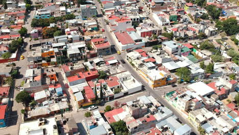 Aerial-footage-of-typical-residential-neighborhood-in-Oaxaca-City,-Mexico-with-traditional-Mexican-houses-and-traffic
