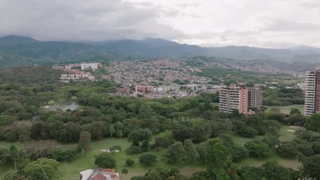 Sobrevuelo-Aéreo-Rápido-De-Edificios-De-Apartamentos-Y-Barrios-Con-Montañas-En-El-Fondo-En-Cali,-Colombia