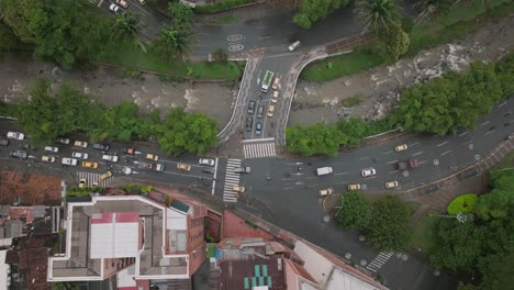 Aerial-wide-top-down-of-traffic-on-a-bridge-with-a-river-underneath-in-downtown-Cali,-Colombia