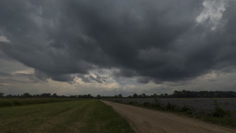 Lapso-De-Tiempo-De-Las-Nubes-Pesadas-Que-Se-Mueven-Rápidamente-Por-Encima-De-La-Carretera