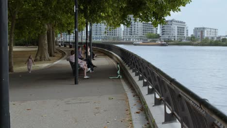 Families-relaxing-in-the-Park-overlooking-the-River-Thames,-London,-UK-4K-CINEMATIC-BRITAIN