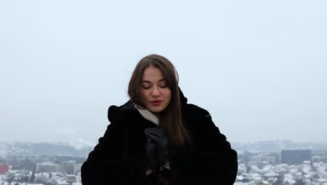 Attractive-female-praying-to-the-sky-outside-on-a-mountain-in-black-coat